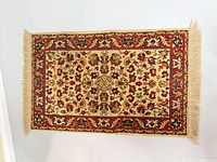 Front view of cream and red Oriental rug with fringe