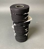 Stack of ten black cloth tape rolls