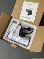 Pinspot light in foam packaging with power cord and manual visible