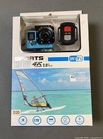 Front of sealed retail box showing camera and remote