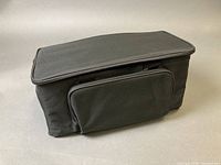 Closed view of black padded carry bag showing exterior front pocket