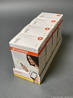 Four sealed retail boxes of Sylvania Smart+ A19 bulbs on tray