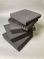 Stack of acoustic foam panels showing wedge edges and uniform size