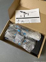 Box opened showing bubble-wrapped rig components and paper manual