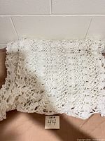Folded white crocheted afghan showing texture and pattern