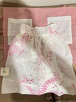 Both aprons stacked, showing striped apron pockets and floral apron front