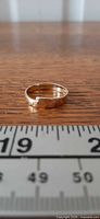 Side profile of gold ring next to ruler for scale