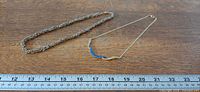 Two necklaces laid next to ruler showing scale