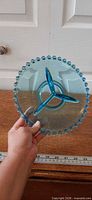 Top view of blue divided dish highlighting beaded rim and three-section divider