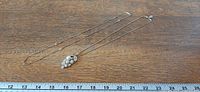 Both necklaces laid flat beside ruler