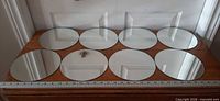 All eight round mirrors aligned for count verification with ruler for scale