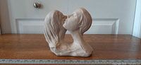 Front view of sculpture showing intertwined busts
