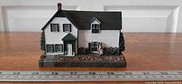 Front view showing full house, walkway and figure with ruler for scale