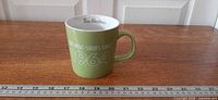 Full mug with ruler for scale showing light green color, white interior, Tim Hortons logo inside rim