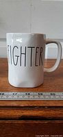 Front view of Rae Dunn "Fighter" mug showing lettering