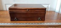 Closed jewelry box front view with ruler for scale