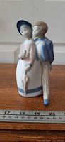 Front view of porcelain couple figurine with ruler for scale