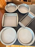 Full lot showing four round pans, square pan, loaf pan with insert