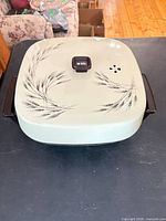 Closed skillet showing wheat pattern lid and handles