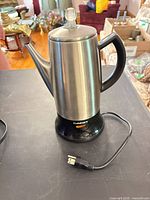 Full view of Cuisinart stainless steel electric kettle on base with power cord visible