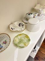Group of assorted porcelain plates, dishes, jars and vases on shelf