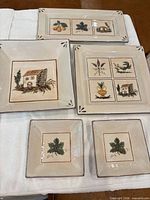 five ceramic pieces laid out: rectangular platter, two large square platters, two small dishes