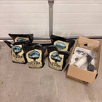 Five guano bags and box of accessories on floor