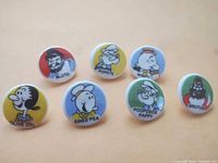 Front view of seven character buttons showing graphics