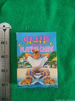 Front of Club Camel playing cards box next to ruler