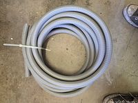 Full view of coiled gray flexible conduit on floor