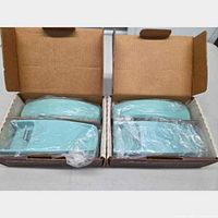 Two baby blue telephones wrapped in plastic inside open boxes