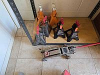 Floor jack and six jack stands on shelf