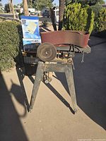 Front view of belt and disc sander on stand with spare belts visible