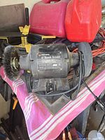 Front view of Black & Decker 6" bench grinder showing label, wire brush wheel, grinding stone, power cord