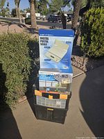 Boxed digital postal scale stacked on plastic toolbox