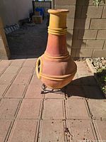 Front view of terracotta chiminea on metal stand