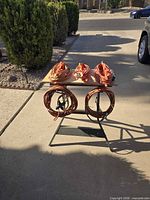 Front view of five coiled orange extension cords on and under a stand
