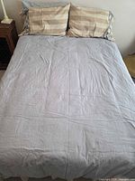 Full size bed made up with pillows and sheet showing overall mattress size
