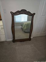 Full view of mirror showing carved wood frame and glass