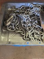 overview of both chains, hook and wire brush inside metal tray