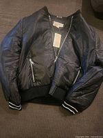 Front view of black bomber jacket with tags attached