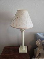 Side view of cream table lamp on wooden surface