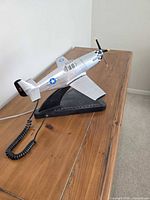 Novelty airplane telephone on stand, silver fuselage with USAAF insignia