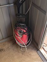 Front view of red electric pressure washer showing cord and hose