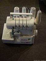 Front view showing brand name, model label, threading, tension dials, and overall appearance