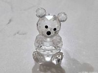 Front view of clear faceted crystal bear showing black eyes and nose