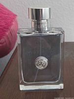 Front view of Versace Pour Homme bottle showing Medusa emblem and liquid level