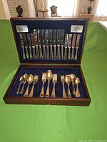 Open wooden case showing full flatware set