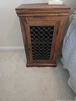Full view of wooden side cabinet showing top, door with metal grille, handle and base