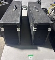 Top view of both long carpeted road cases showing handles, clasps, corner guards